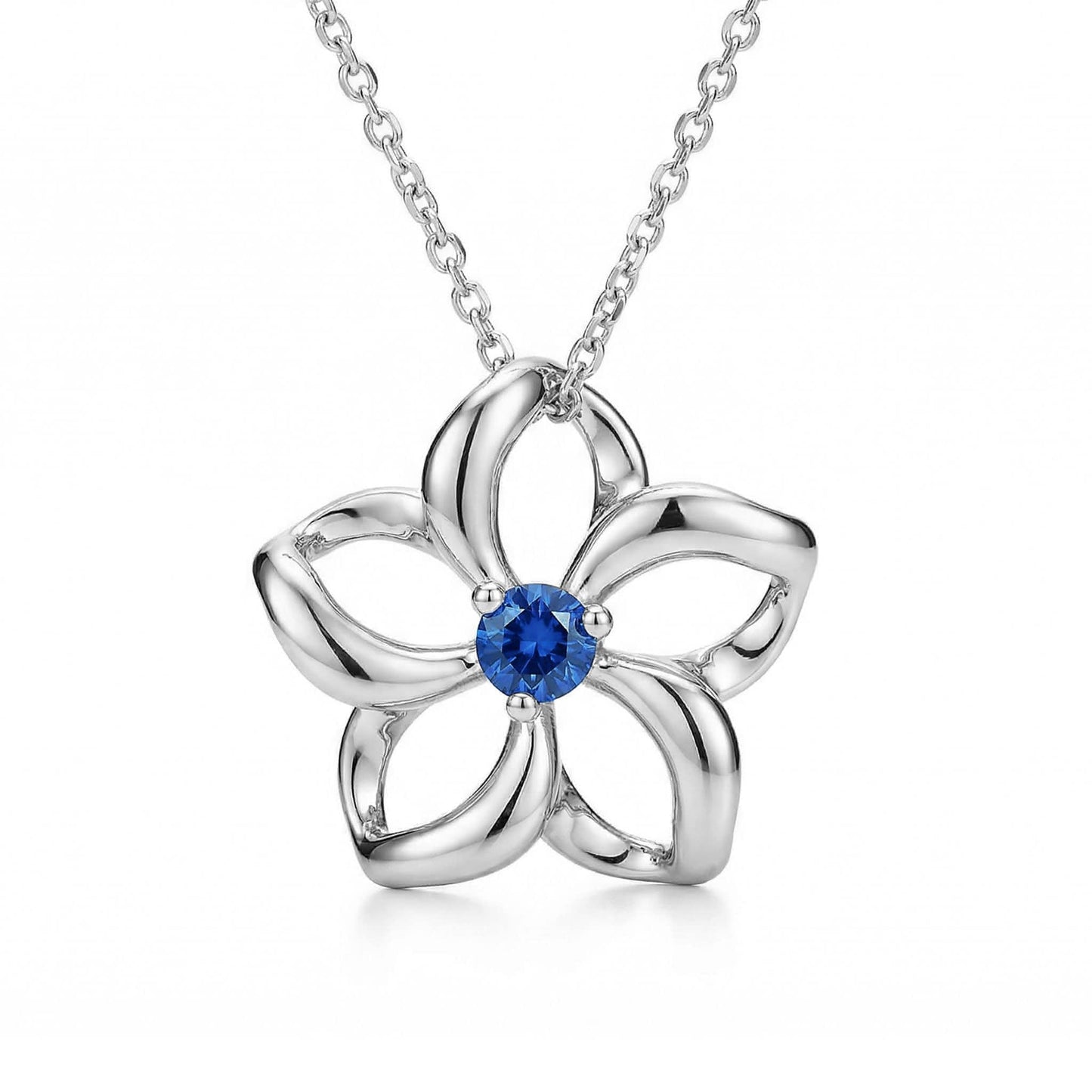 Graceful white gold pendant shaped like the iconic plumeria, centered with a stunning blue sapphire stone. Item No. 40039