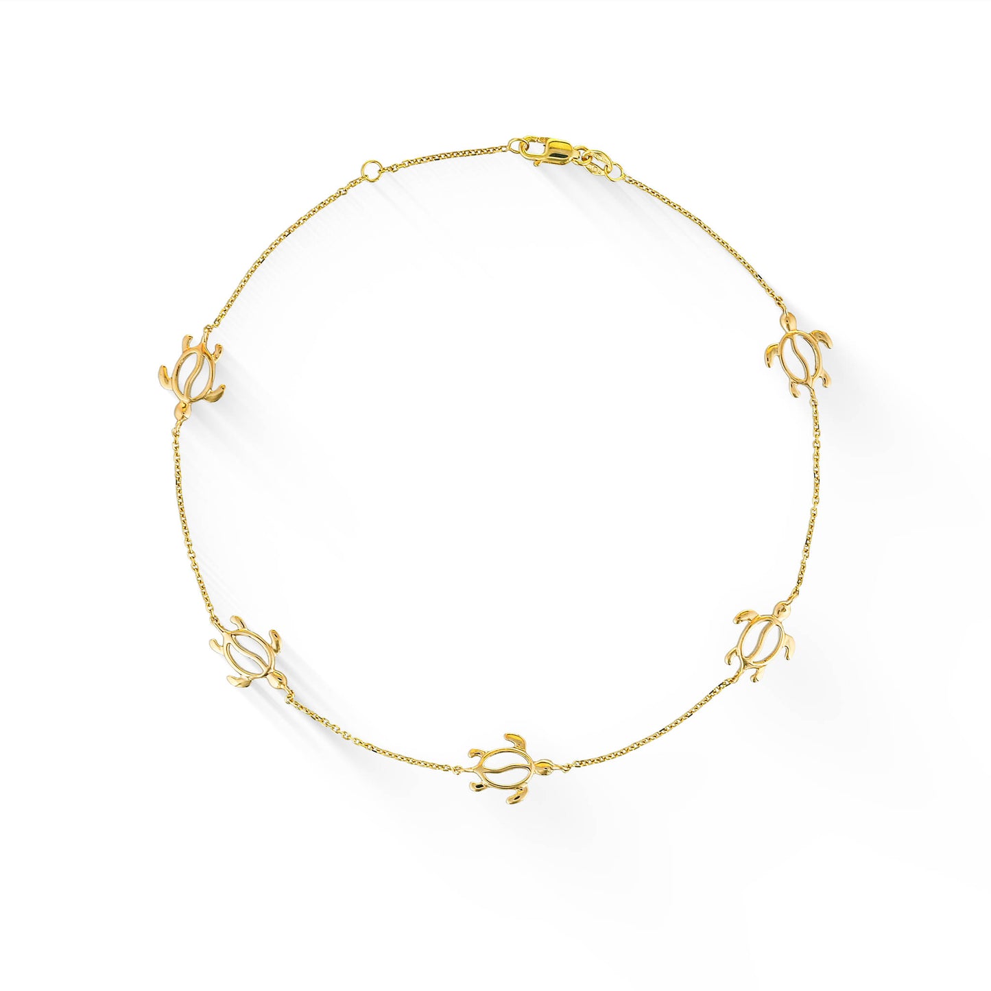 Overhead view of a 14K yellow gold honu anklet with five stationary sea turtle charms on a delicate chain. Item No. 44640