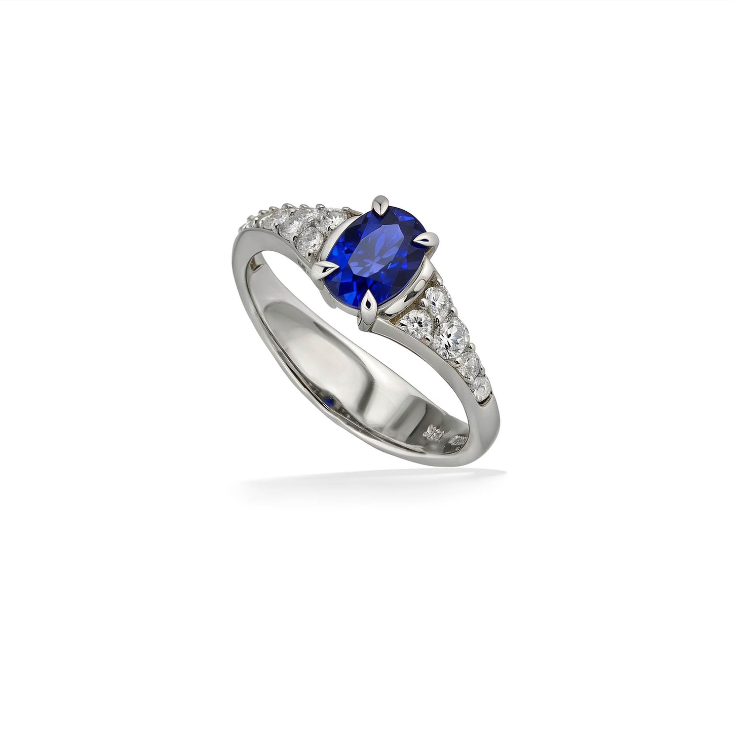 Angled view of white gold sapphire ring highlighting prong-set center stone and pavé side diamonds. Item No. 45050