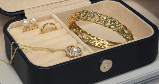 Jewelry set including a necklace, earrings, and bracelet in an open jewelry box.