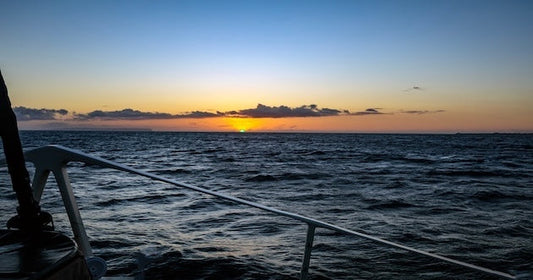 View of the green flash sunset phenomenon over the ocean from a boat