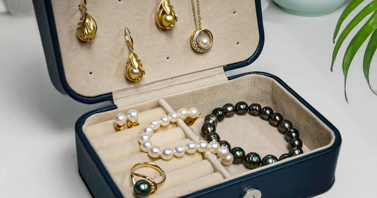 Jewelry set including earrings, necklace, bracelet, and ring in an open jewelry box.