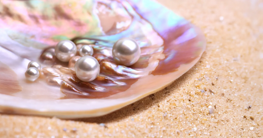 Pearls inside a pink shell on beach sand