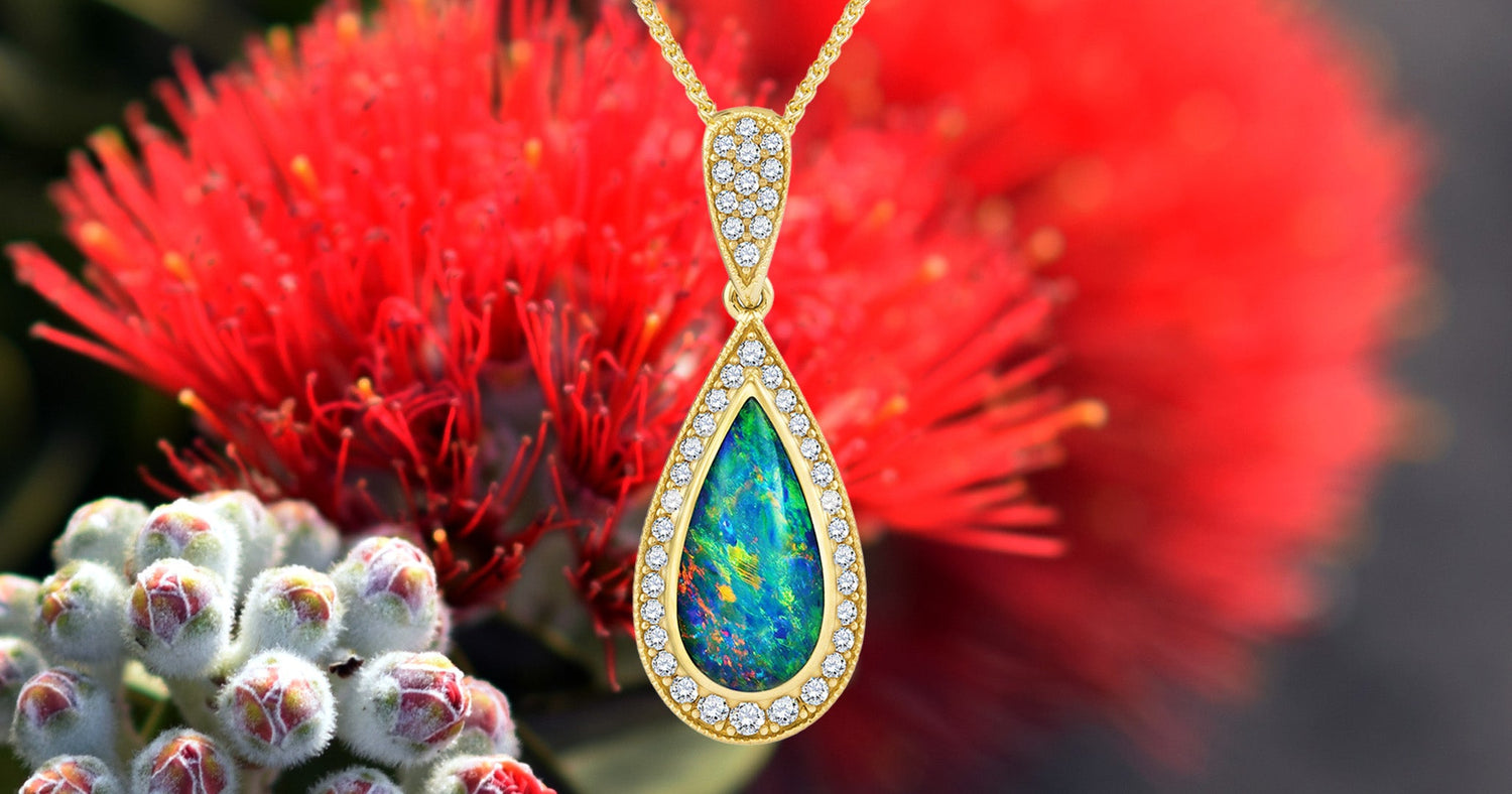Opal pendant necklace with a red flower and white flowers in the background