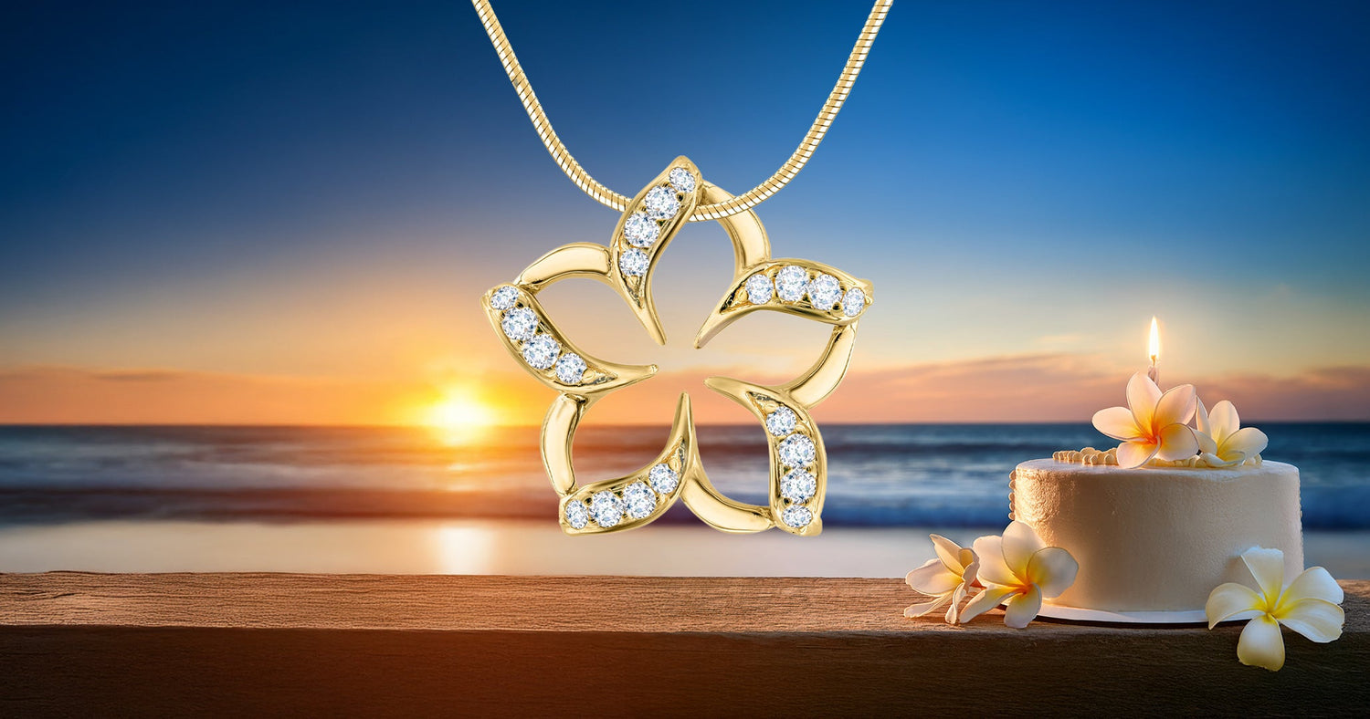 Gold Floating Plumeria Pendant with Diamonds and birthday cake with flowers against beach sunset