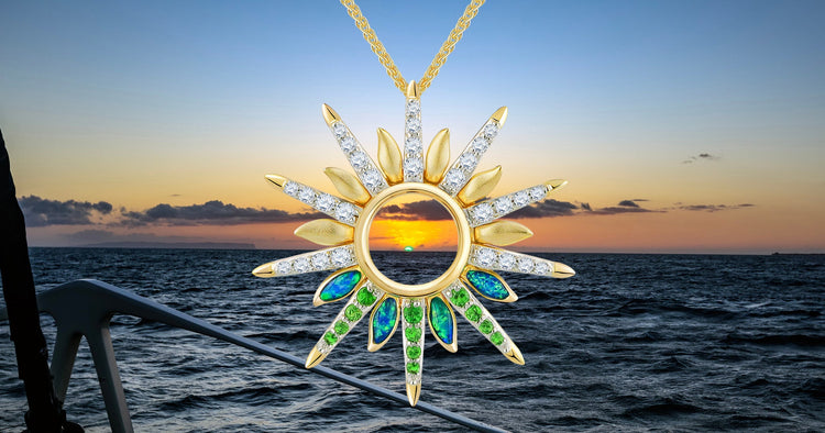 Green Flash Sunset pendant with gemstones against a sunset over water