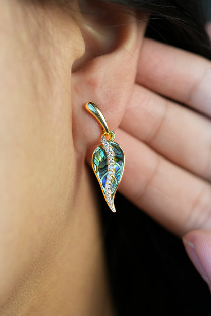 Close-up of a person wearing a Maile leaf-shaped earring in gold, abalone and diamonds - 44482