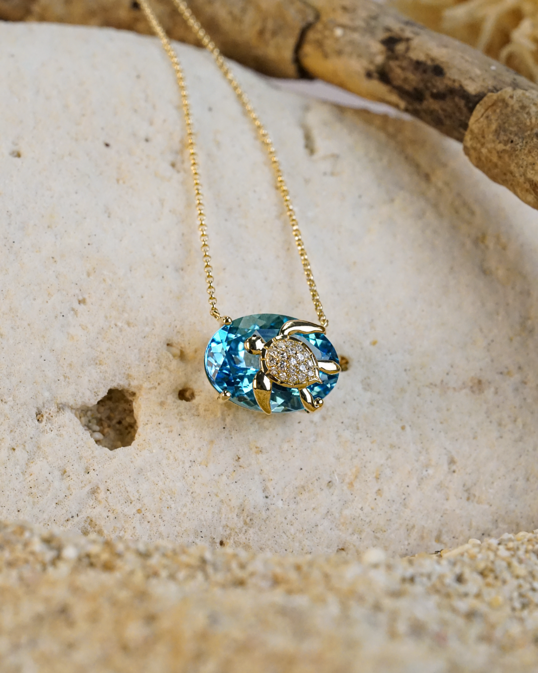Blue Topaz and Diamond Turtle Necklace on a sandy background. Item 773775
