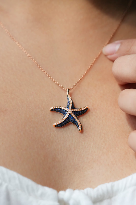 Starfish-shaped rose gold necklace with blue sapphires and diamonds worn by a person - 777233