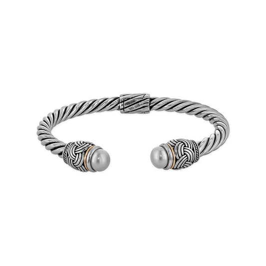 A twisted sterling silver cuff bracelet with woven patterns, gold accents & freshwater pearls on each end. Item No. 700678