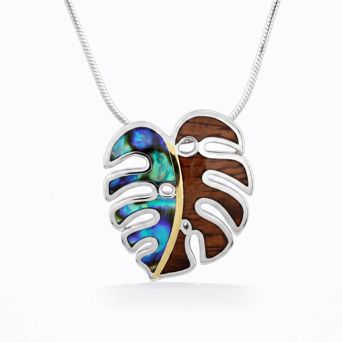 Sterling silver monstera leaf with abalone and koa wood inside split in half by 18K gold strip. Item No. 45509
