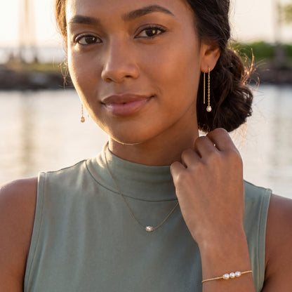 Model wearing Pearl Flower necklace, earrings and bracelet in yellow gold. Item No. 45412